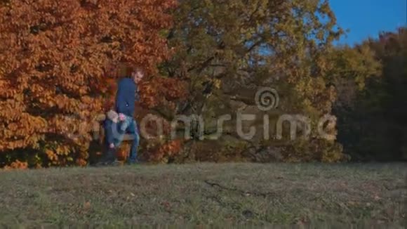 爸爸牵着儿子的手在公园里散步视频的预览图