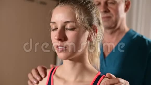 男性手动内脏治疗师按摩师治疗年轻女性患者编辑颈部和椎骨视频的预览图