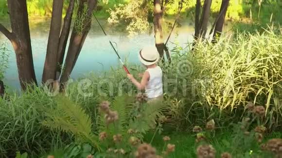 孩子们在池塘边钓鱼两个钓鱼的小渔夫小兄弟从湖边走视频的预览图