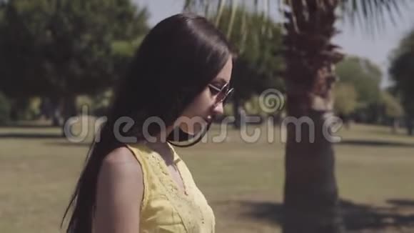美丽的女孩走在棕榈树上视频的预览图