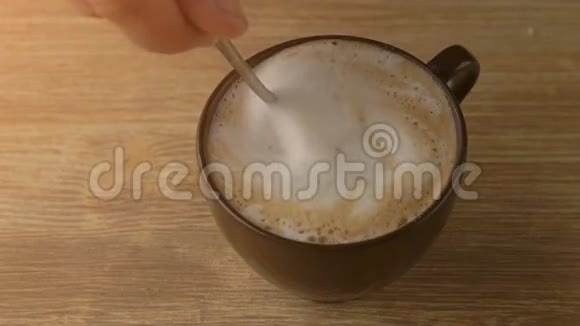 将卡布奇诺咖啡泡沫与勺子混合紧密视频的预览图