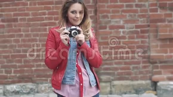 一位年轻迷人的女士手中拿着一部复古的照片相机的肖像视频的预览图