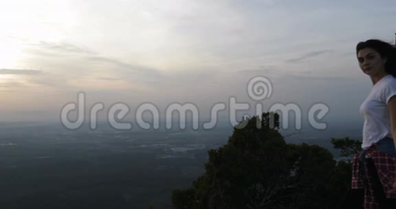 山顶上的一对夫妇抱着胳膊享受风早晨的男女快乐视频的预览图