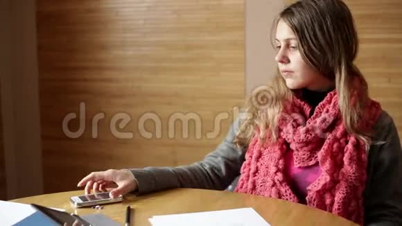 办公室的女人坐在工作桌前用手机发短信视频的预览图