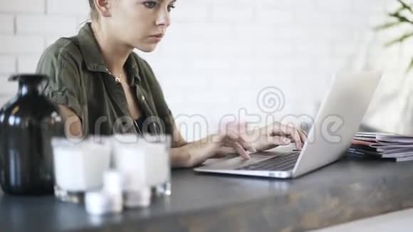 年轻女子在办公室的笔记本电脑上打字倾斜视频的预览图