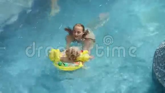 女孩和她弟弟在游泳池里玩视频的预览图