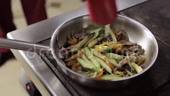 厨师用蒜蓉加入橄榄油煎锅与蔬菜视频的预览图