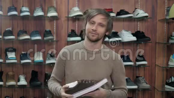 在极限运动商店里选择新运动鞋的男人视频的预览图