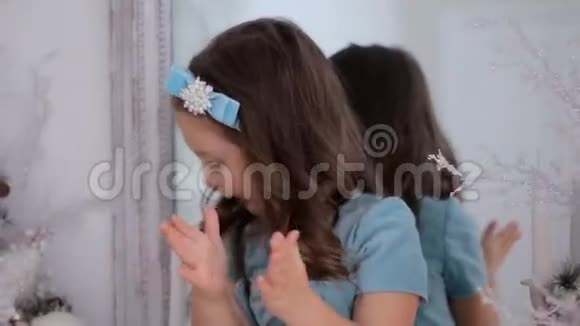 穿着蓝色裙子的小女孩坐在镜子前视频的预览图