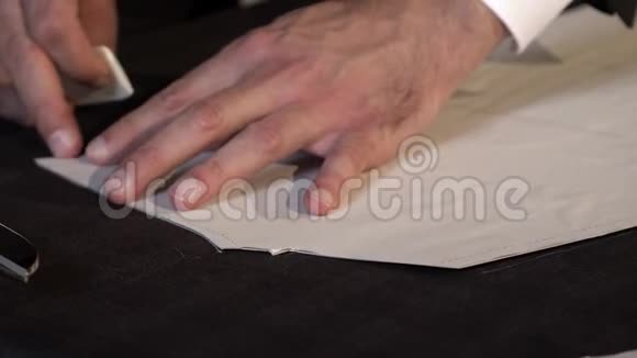 一个裁缝在裁剪成零件之前在织物上画出最后的线条视频的预览图