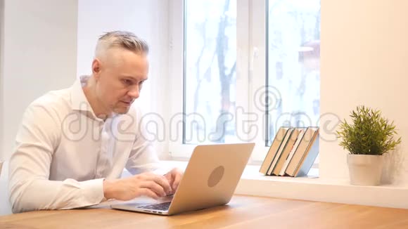 中年男子在手提电脑工作时因丢失而心烦意乱视频的预览图