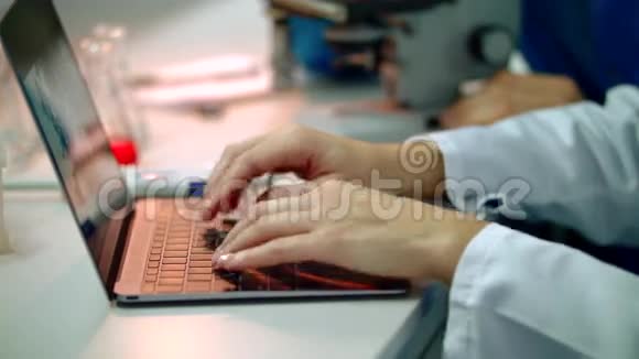 科学家手在笔记本电脑上打字把女科学家手举在笔记本电脑上视频的预览图