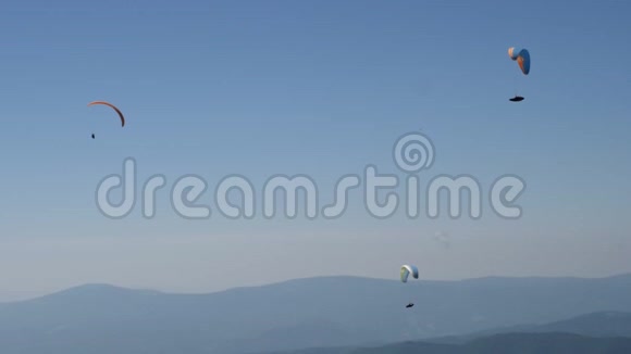 三个滑翔伞在晴朗的蓝天中飞行视频的预览图
