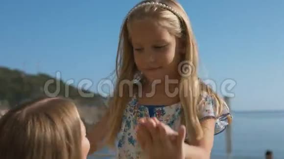 妈妈和小女儿在海边的公园里散步视频的预览图
