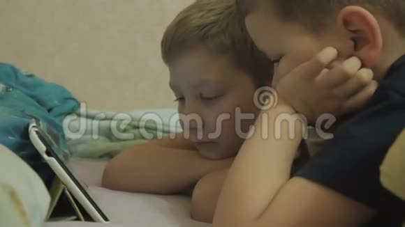 孩子们躺在床上看表演视频的预览图