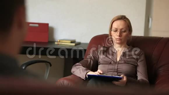 咨询心理学家一位女性治疗师正在咨询一位患有焦虑症的男性患者视频的预览图