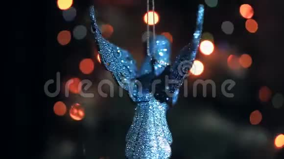 一个闪闪发光的圣诞装饰为一棵圣诞树的形状一只鸟在花环的灯光下旋转视频的预览图