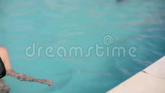 一位身穿湿泳衣的性感年轻女子从泳池里走出来视频的预览图