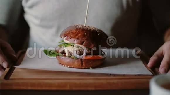 美味的汉堡在木制托盘上很棒一个人牵着他的手准备吃饭视频的预览图