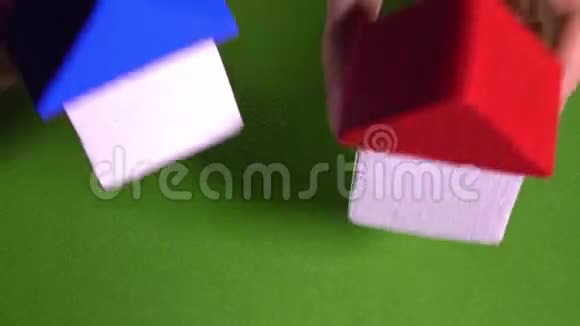 房地产经纪人在绿色背景下放置红色和模糊屋顶的玩具屋发展概念4K视频视频的预览图