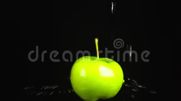 绿色苹果特写水滴落在黑色背景上旋转的苹果上超级慢动作视频的预览图