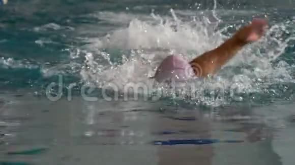 动作一个运动员一个女人用一种姿势爬行游泳参加游泳比赛的女游泳运动员她是视频的预览图