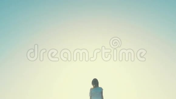 穿着白色连衣裙的女孩从日落走到相机沙漠视频的预览图