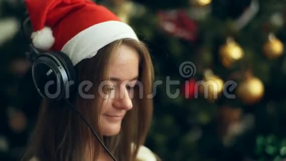 戴着圣诞帽的黑发美女听音乐视频的预览图