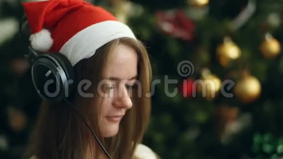 戴着圣诞帽的黑发美女听音乐唱歌视频的预览图