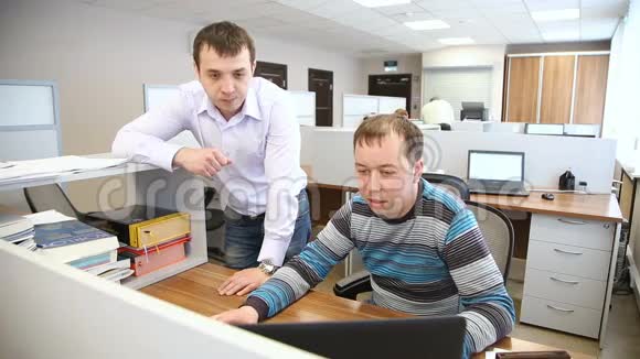 办公室里的男人讨论站在电脑前的工作问题视频的预览图