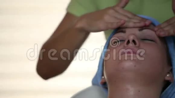 在治疗师按摩时特写女性面部照片视频的预览图