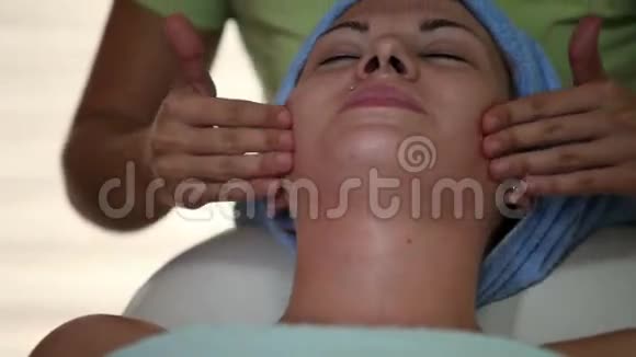 女性治疗师轻轻按摩面部皮肤视频的预览图