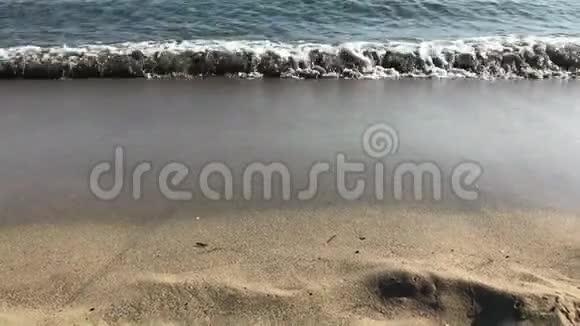 海浪轻轻拍打在宁静的沙滩上视频的预览图
