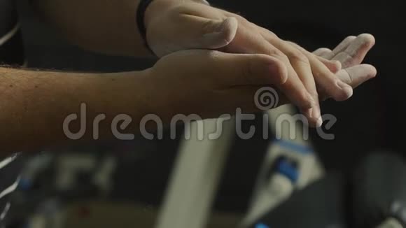 一个男人在健身房用滑石粉搓手视频的预览图