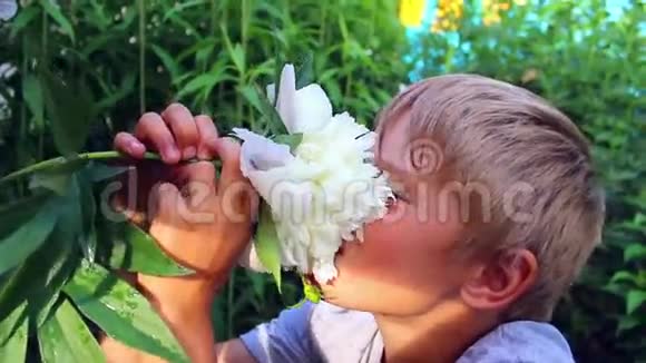孩子吸入盛开的花朵的香气视频的预览图