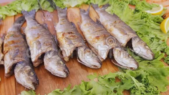 烤红鲑鱼加沙拉在美食节的餐桌上放着蔬菜和柠檬的煮熟的鱼片视频的预览图