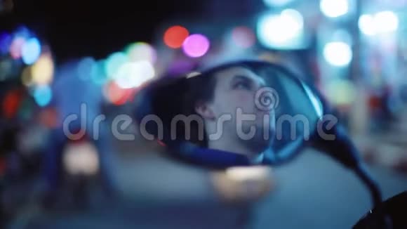 年轻的大胡子帅哥开着摩托车在夜色中照在镜子上模糊的薄纱轻夜美丽视频的预览图