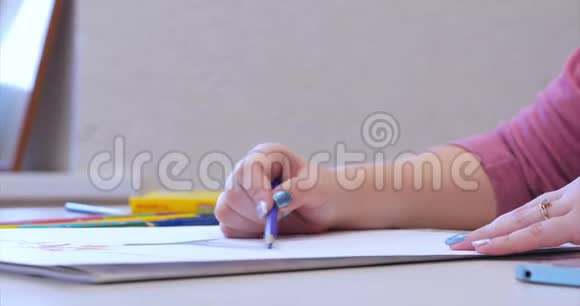 年轻的艺术家的手女艺术家用石墨铅笔画画布坐在桌子上画画布视频的预览图