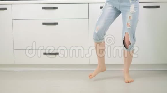 快乐的年轻有趣的女人在家里的厨房里跳舞视频的预览图