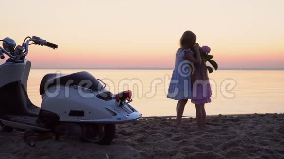 两个小妹妹被拍到在海滨的白色摩托上两个头发花白的小女孩摆姿势拍照视频的预览图