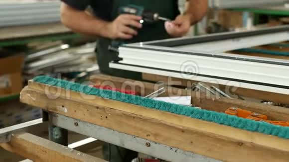 生产制造pvc窗男工装配pvc型材窗紧固铰链零件视频的预览图