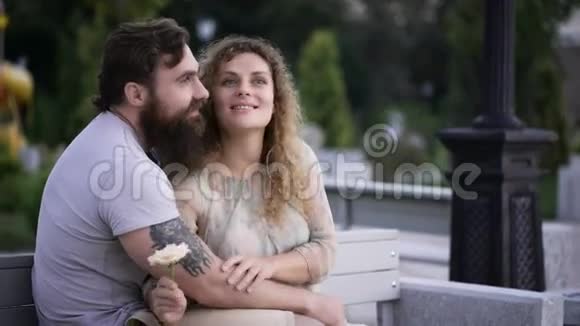 可爱的夫妇在公园里的白色长凳上视频的预览图