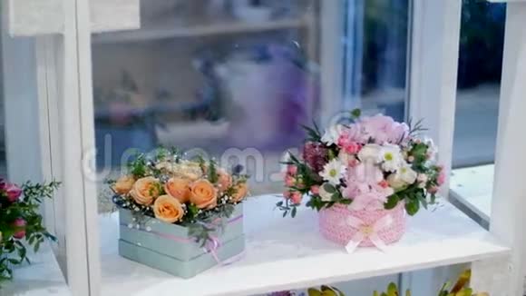 花店在橱窗上有很多花束花型的组合在五颜六色的盒子里视频的预览图