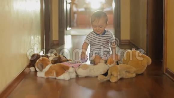 可爱的10个月大的男孩在地板上玩毛绒玩具视频的预览图
