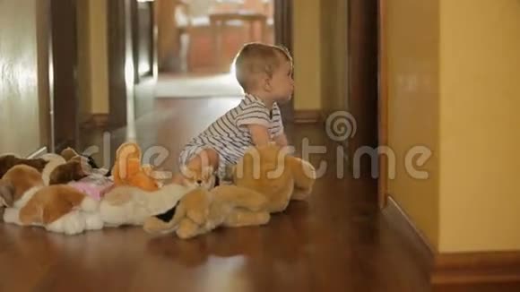 可爱的10个月大的男孩在地板上玩毛绒玩具视频的预览图