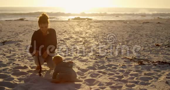 妈妈在海滩上和她的小男孩玩耍视频的预览图