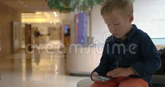 儿童在贸易中心的手机上翻拍照片视频的预览图