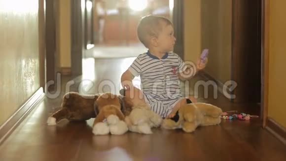 可爱的10个月大的男孩在地板上玩填充玩具视频的预览图