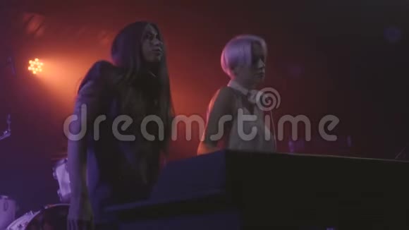 两位年轻美女DJ在夜总会慢动作的混合控制台播放音乐视频的预览图