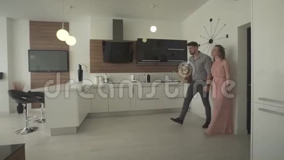 年轻兴奋快乐的一对情侣环视室内厨房现代时尚设计4k镜头移动新公寓视频的预览图
